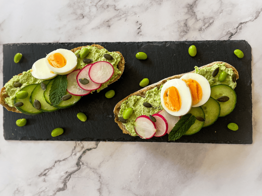 Edamame spread on sourdough topped with vegetables